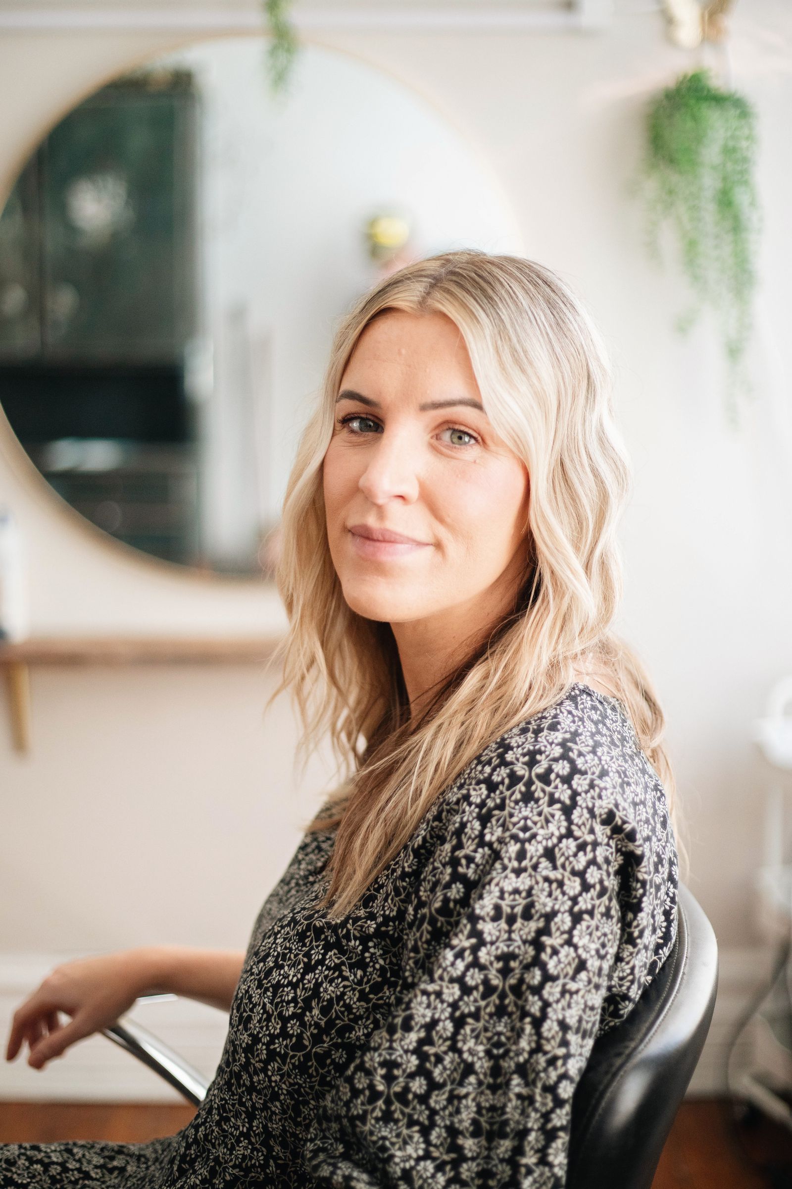 Natural light portrait of a woman in a salon, highlighting natural beauty and professional style.