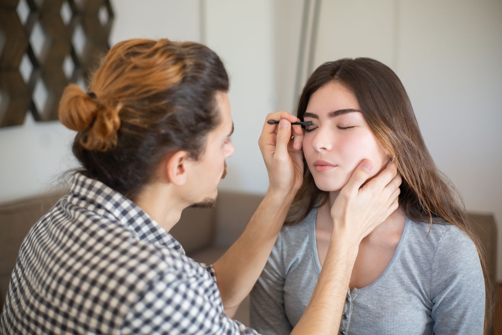 An artist working carefully around a client's brow line